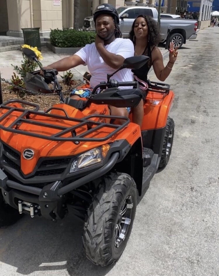 Couple riding an orange ATV through Nassau